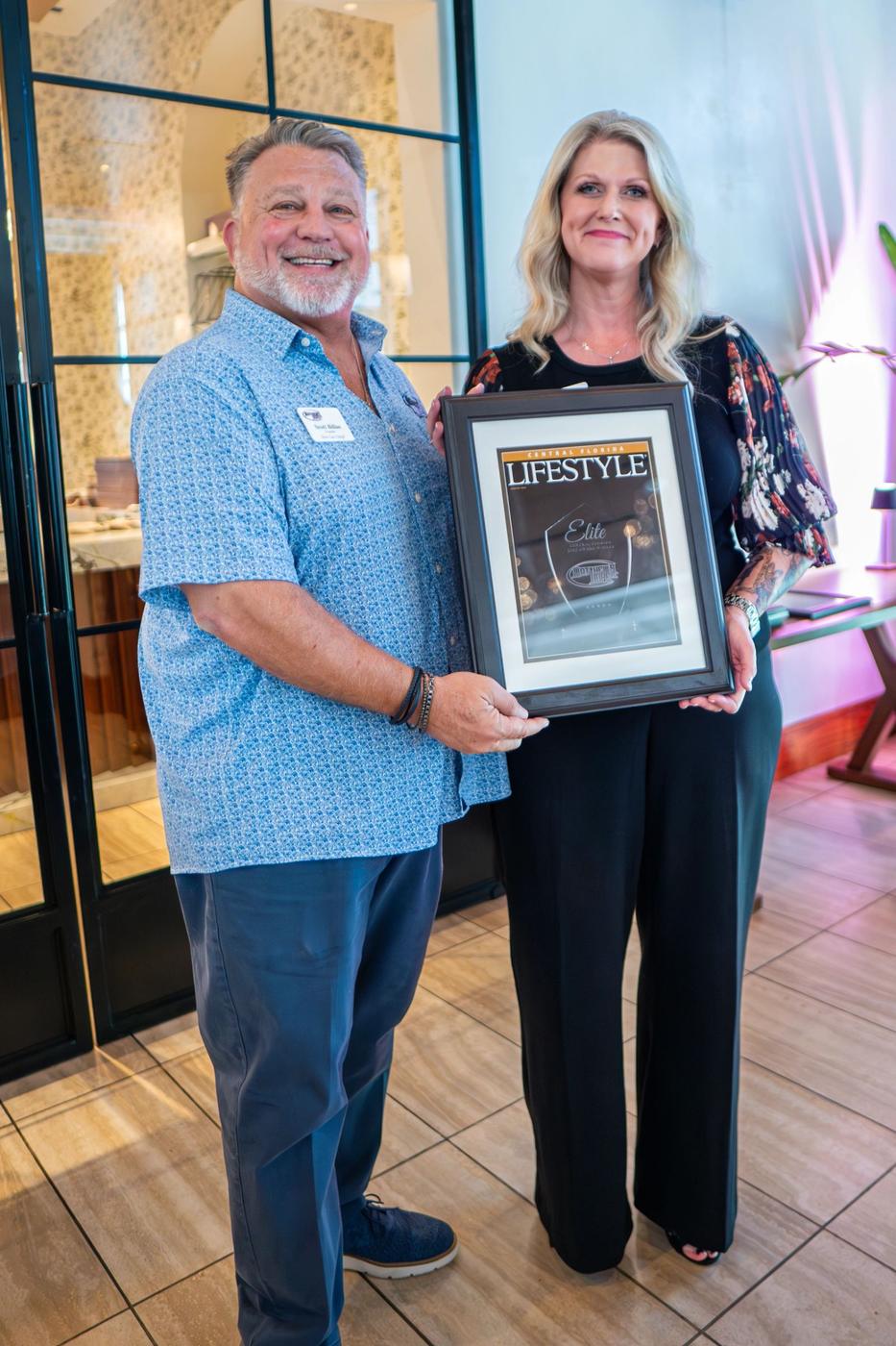A past winner holding an Elite award plaque